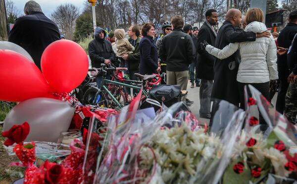 A group gathered at the memorial for Alexia Hyneman after the Grady High School freshman was hit and killed while riding her bicycle at 10th Street and Monroe Drive in 2016. (John Spink/AJC)