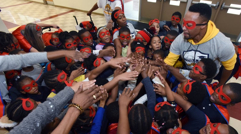 Assistant principal Robert Stewart (right) cheers students after they participated in the attendance run at Miles Elementary School on Friday, Nov. 22, 2019. On Fridays, Miles students with good attendance are allowed to run around the school hallways dressed up in capes and masks as superheroes. It is one of many strategies Atlanta school leaders are using to improve student attendance rates and combat chronic absenteeism. HYOSUB SHIN / HYOSUB.SHIN@AJC.COM