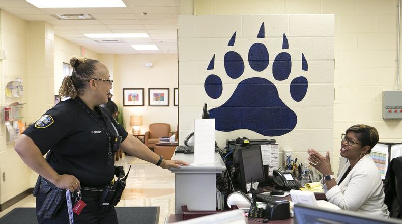 Officer Diane Moody (left) chats with Barnwell Elementary professional assistant Niki McKenzie at the front desk of Barnwell Elementary School in Johns Creek on Sept. 20, 2018. Newly released federal school safety guidelines call for training for school personnel, which is similar to recommendations released last month by the state Senate School Safety Study Committee. CASEY SYKES / CASEY.SYKES@AJC.COM