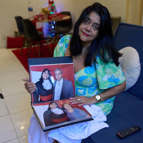 Simone Guimarães holds a photo of herself with her husband, who died from COVID at her home in Sao Goncalo, Rio de Janeiro state, Wednesday, Nov 19, 2025. (AP Photo/Silvia Izquierdo)