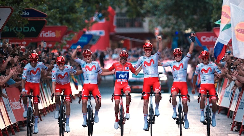 Spain's Enric Mas, center, flanked by his teammates, celebrates as he crosses the finish line after winning the overall classification of the Spanish Vuelta cycling race in Granada, Spain, Sunday, Sept. 13, 2026. (AP Photo/Gregorio Marrero)
