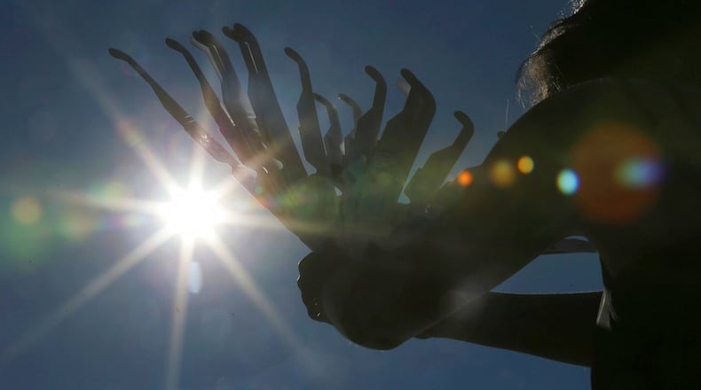 Ashley Ann Sander hawks solar eclipse glasses on the side of the road for $10 to tourists approaching Clayton, Ga., Sunday, Aug. 20, 2017. Clayton is in the path of totality in North Georgia. (Curtis Compton/Atlanta Journal-Constitution via AP)