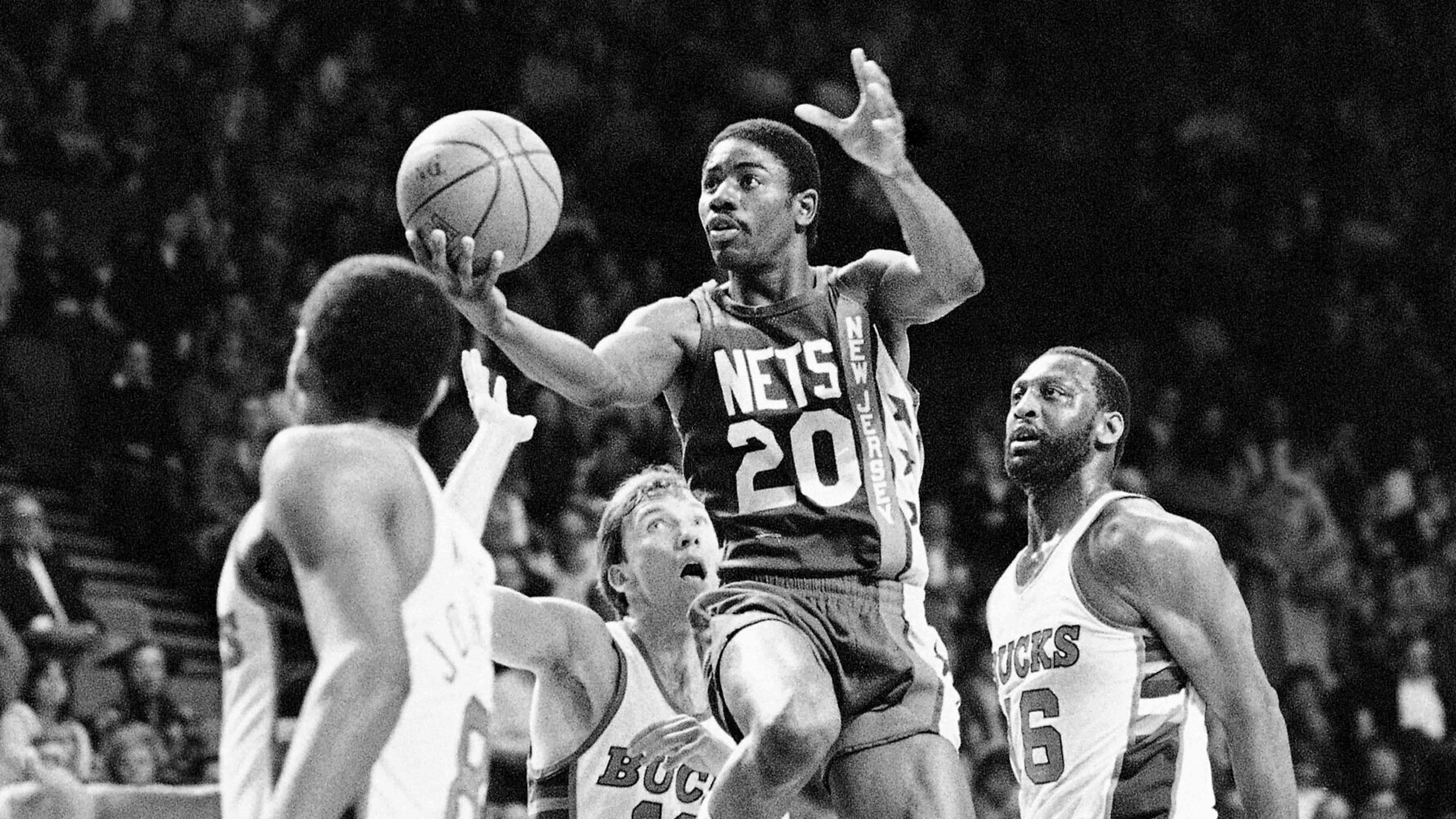 FILE - New Jersey Nets; Michael Ray Richardson (20) drives to the basket past Milwaukee Bucks' Mike Dunleavy (10) and Bob Lanier (16) during the first quarter of an NBA basketball playoff game, May 8, 1984, Milwaukee. (AP Photo/Tom Lynn, FIle)