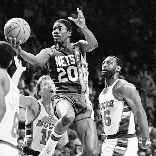FILE - New Jersey Nets; Michael Ray Richardson (20) drives to the basket past Milwaukee Bucks' Mike Dunleavy (10) and Bob Lanier (16) during the first quarter of an NBA basketball playoff game, May 8, 1984, Milwaukee. (AP Photo/Tom Lynn, FIle)