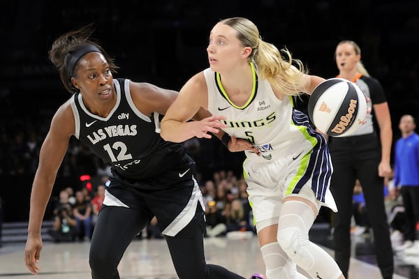 Dallas Wings guard Paige Bueckers (5) drives against Las Vegas Aces guard Chelsea Gray (12) during the first half of a WNBA basketball game Friday, June 13, 2025, in Las Vegas. (Steve Marcus/Las Vegas Sun via AP)