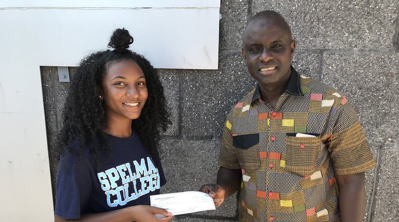Destinee Whitaker, a recent graduate of Philadelphia’s George Washington Carver High School of Engineering and Science, presents a check to Joseph Sackor of the Liberian Medical Mission for water purification systems. (Courtesy Carver High School of Engineering and Science/TNS)
