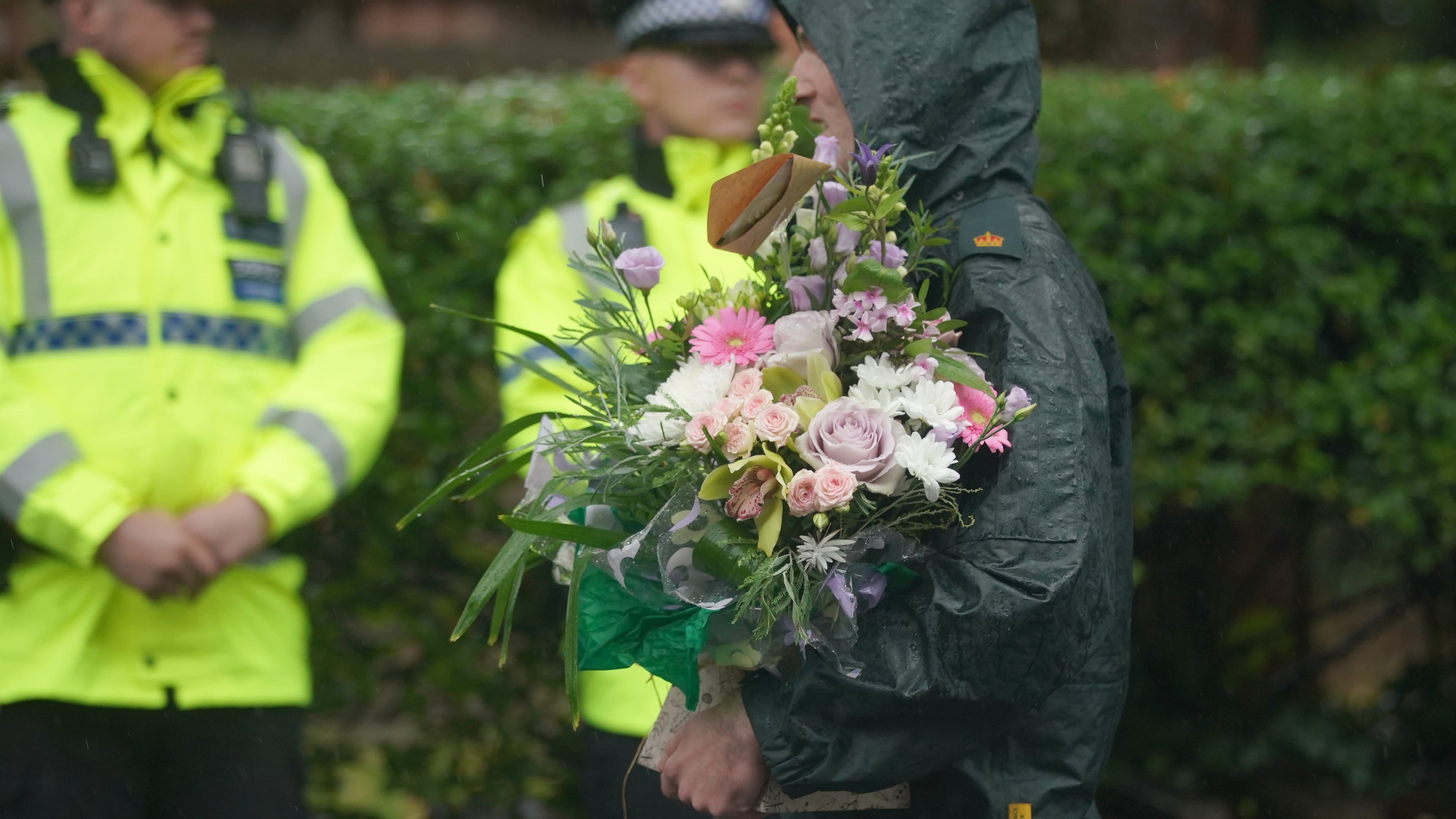 A woman brings flowers as she attends a vigil for the victims of the attack on the Heaton Park Hebrew Congregation synagogue, in Crumpsall, Manchester, England, Friday, Oct. 3, 2025, the attack happened Thursday. (AP Photo/Ian Hodgson)