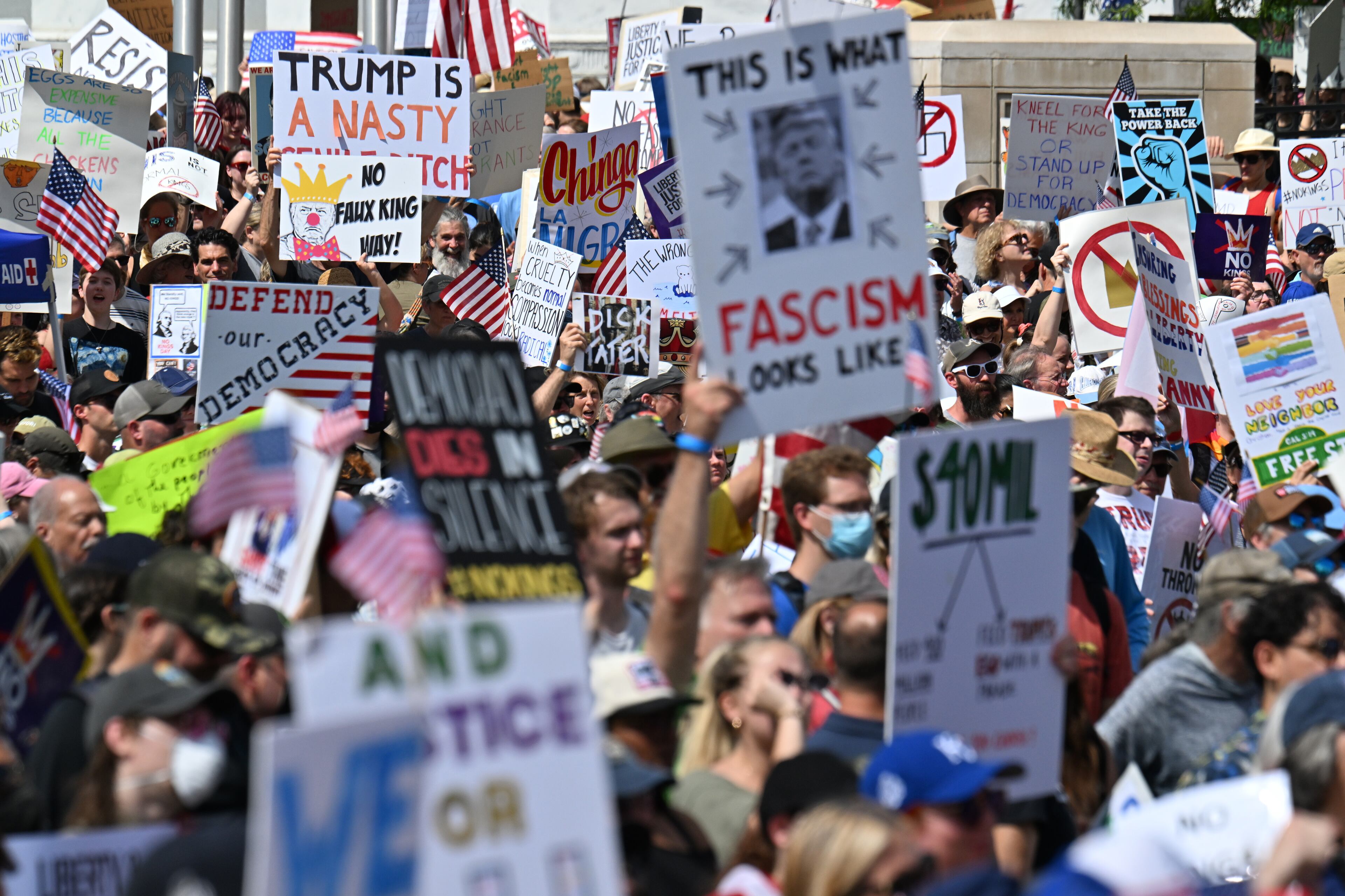 Demonstrators hold signs at Liberty Plaza, near the Georgia Capitol, for a "No Kings" protest to oppose Trump’s immigration policies, Saturday, June 14, 2025, in Atlanta. (Hyosub Shin / AJC)