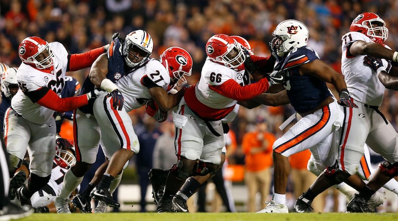 FILE - In this Saturday, Nov. 11, 2017, file photo, Auburnâs Dontavius Russell, second from left, tackles Georgia's  Nick Chubb (27), as Georgia's Kendall Baker (65) and Solomon Kindley (66), Auburn's Andrew Williams (79) and Georgia's Andrew Thomas (71) join in the play during the second half of an NCAA college football game in Auburn, Ala. Auburn defensive coordinator Kevin Steele wanted his defense to go from good to very good to playing like an elite group. The sixth-ranked Tigers delivered on all counts in a win over Georgia.  (AP Photo/Brynn Anderson, File)