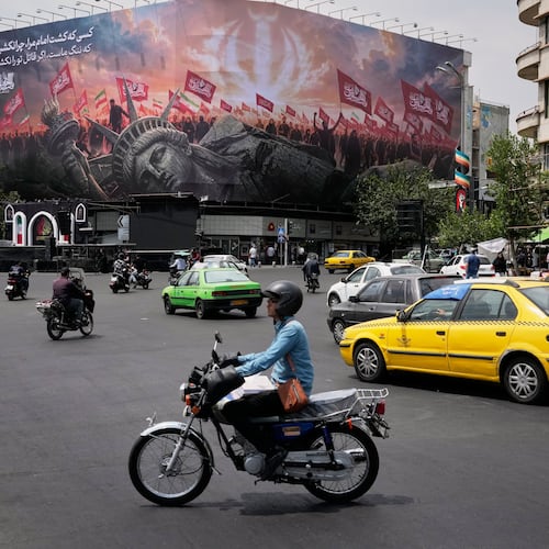 Vehicles travel past a billboard depicting a fallen Statue of Liberty and crowds carrying Iranian and Shiite flags at Revolution Square in Tehran, Iran, Monday, Aug. 3, 2026. (AP Photo/Vahid Salemi)