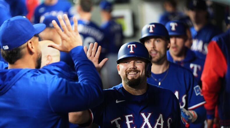 Texas Rangers' Jake Burger is greeted in the dugout after scoring on a two-run single from Justin Foscue during the fourth inning of a baseball game against the Seattle Mariners, Tuesday, Sept. 8, 2026, in Seattle. (AP Photo/Lindsey Wasson)