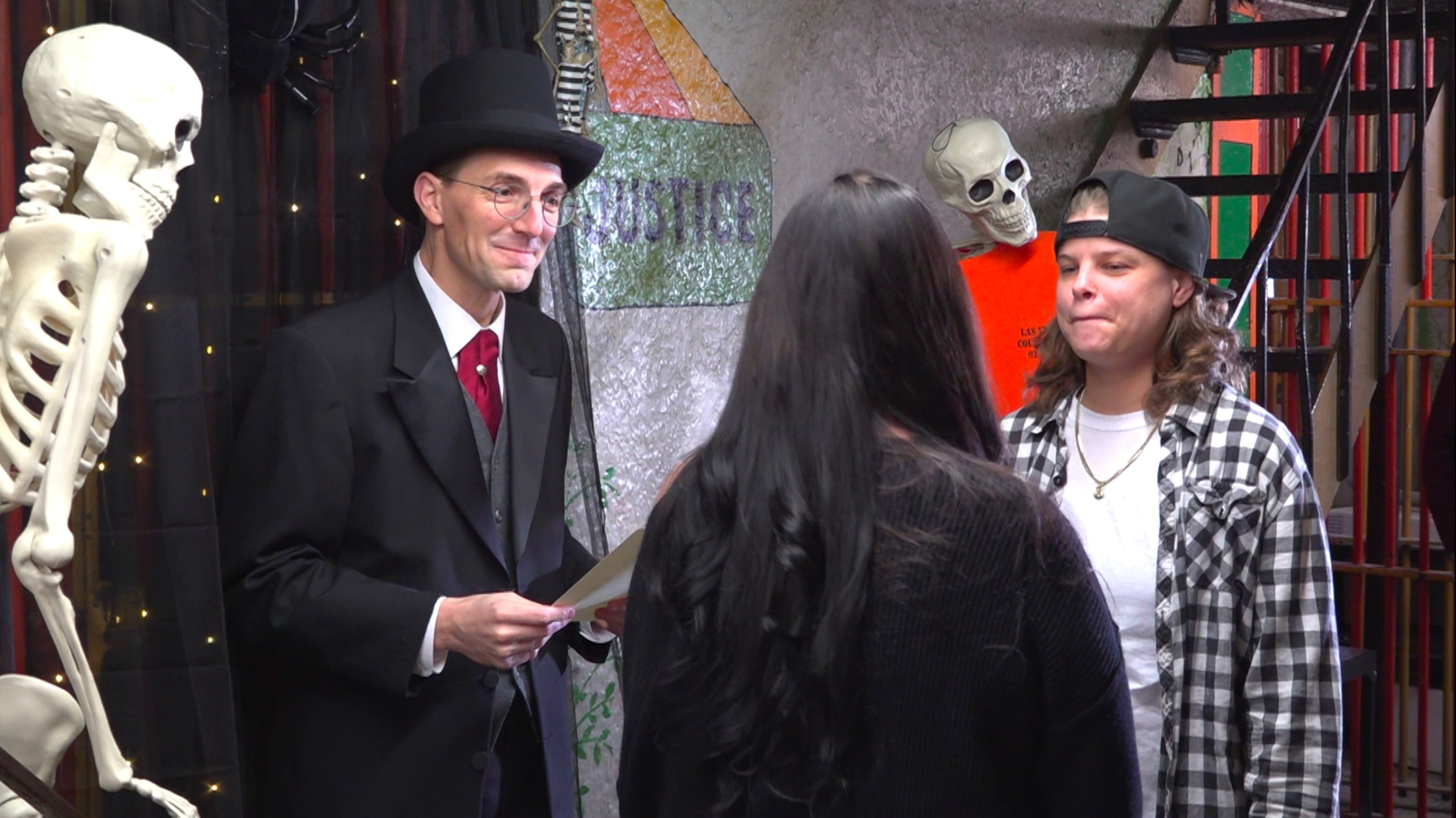 This photo taken from video shows Judge David Hejmanowski, back left, officiating the wedding of Andrea Bates, center, and Jessica Scales at the Historic Jail and Sheriff's Residence on Friday, Oct. 31, 2025, in Delaware, Ohio. (AP Photo/Patrick Aftoora-Orsagos)