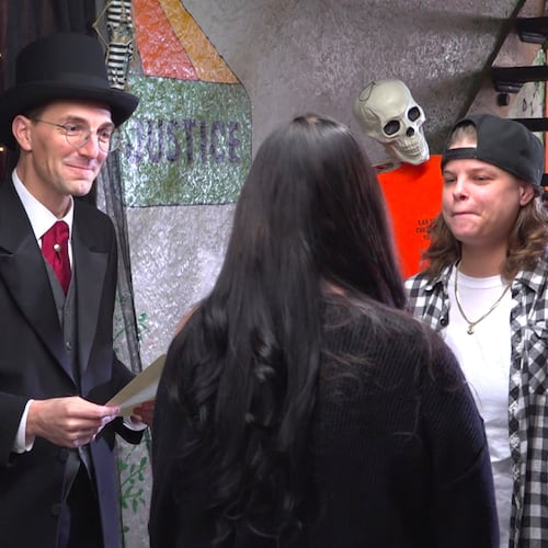 This photo taken from video shows Judge David Hejmanowski, back left, officiating the wedding of Andrea Bates, center, and Jessica Scales at the Historic Jail and Sheriff's Residence on Friday, Oct. 31, 2025, in Delaware, Ohio. (AP Photo/Patrick Aftoora-Orsagos)