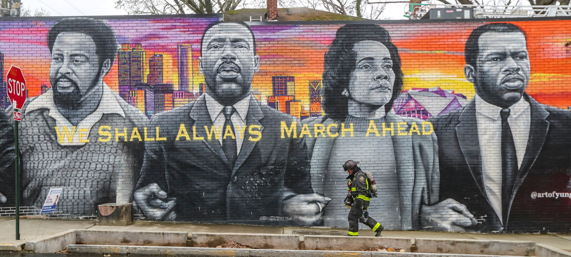 Fire Captain Jason Johnson of Truck 14 makes his way up Joseph E. Boone Boulevard along a civil rights mural after a fire around the corner at an old home converted into apartments in northwest Atlanta on March 2, 2023. (John Spink / John.Spink@ajc.com)


