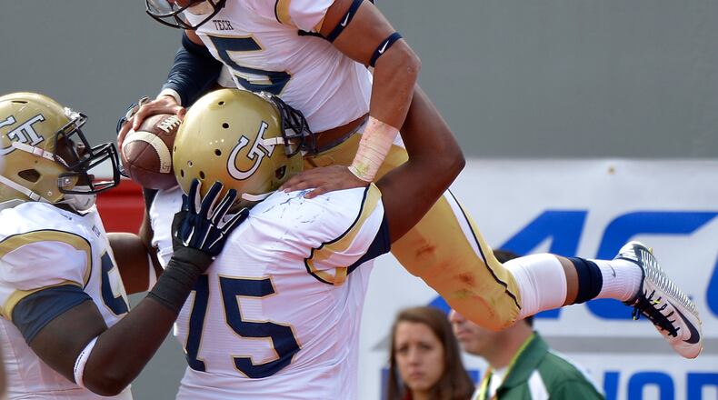 RALEIGH, NC - NOVEMBER 08: Justin Thomas #5 celebrates with teammates after scoring a touchdown against the North Carolina State Wolfpack during their game at Carter-Finley Stadium on November 8, 2014 in Raleigh, North Carolina. (Photo by Grant Halverson/Getty Images) Justin Thomas celebrates after first of eight Georgia Tech touchdowns. (Grant Halverson/Getty Images).