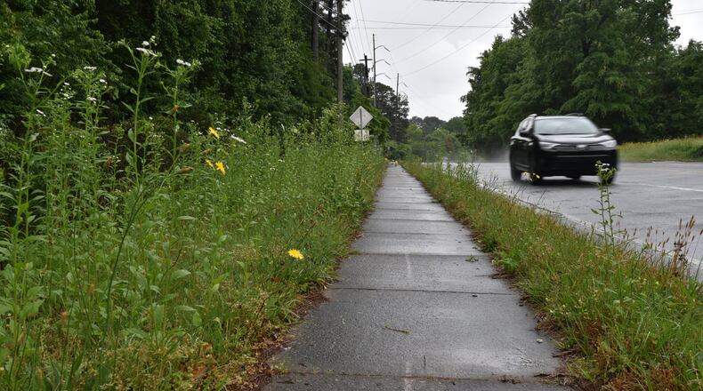 Picture shows overgrown grass, weeds and bushes along Chamblee-Tucker Road on Wednesday. Portions of this road are among 125 streets currently scheduled for mowing once every quarter, which DeKalb CEO Mike Thurmond says is unacceptable. HYOSUB SHIN / HSHIN@AJC.COM