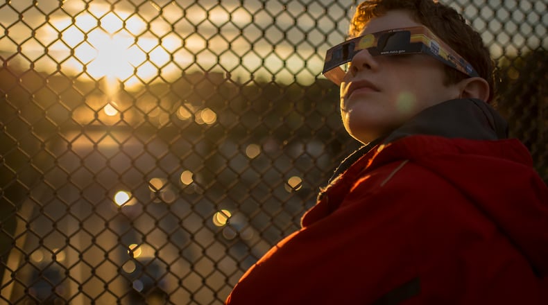 In this handout photo provided by NASA, Alex Frye, 12, uses special viewing glasses to look at a partial solar eclipse from a highway overpass October 23, 2014, in Arlington, Virginia. (Photo by Bill Ingalls/NASA via Getty Images)