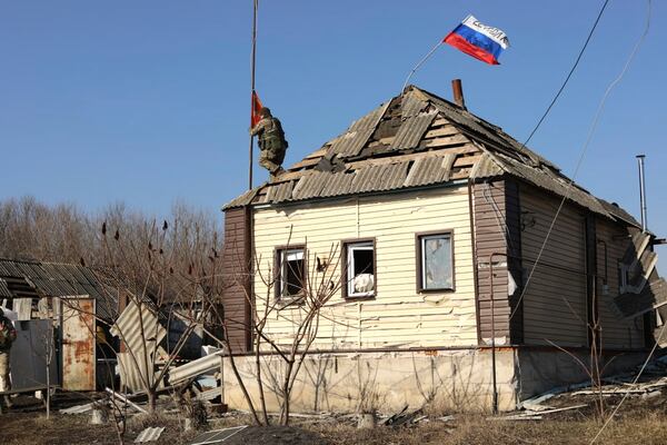 FILE - In this image made from a video distributed by the Russian Defense Ministry Press Service on Friday, March 14, 2025, a Russian soldier raises a red flag over a house in the Kursk region of Russia. (Russian Defense Ministry Press Service via AP, File)