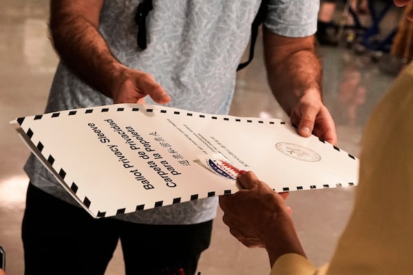 A voter receives his ballot at PS811, The Mickey Mantle School, in the mayoral primary election in New York, Tuesday, June 24, 2025. (AP Photo/Richard Drew)