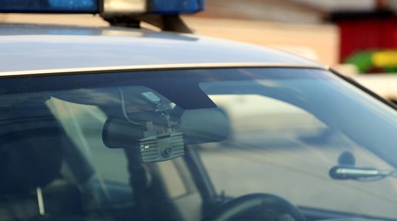 Police dash and body cams captured dramatic footage of the rescue of a woman who had jumped on top of a concrete barrier on an interstate bridge.