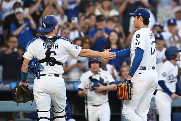Los Angeles Dodgers starting pitcher Shohei Ohtani, right, shakes hands with catcher Will Smith during the first inning of a baseball game against the San Diego Padres, Monday, June 16, 2025, in Los Angeles. (AP Photo/Kyusung Gong)