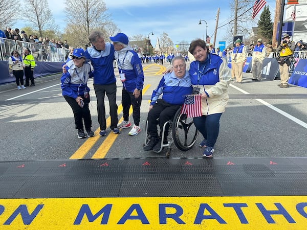Four-time Boston Marathon winner Bill Rodgers and wheelchair athlete pioneer Bob Hall greet race volunteers at the start of the Boston Marathon Monday April 21, 2025. They are the grand marshals of the 129th Boston Marathon. (AP Photo/ Jennifer McDermott)