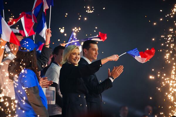 FILE - French far-right National Rally party leader Marine Le Pen, center, and President Jordan Bardella salute supporters at a meeting in Marseille, southern France, March 3, 2024. (AP Photo/Daniel Cole, File)