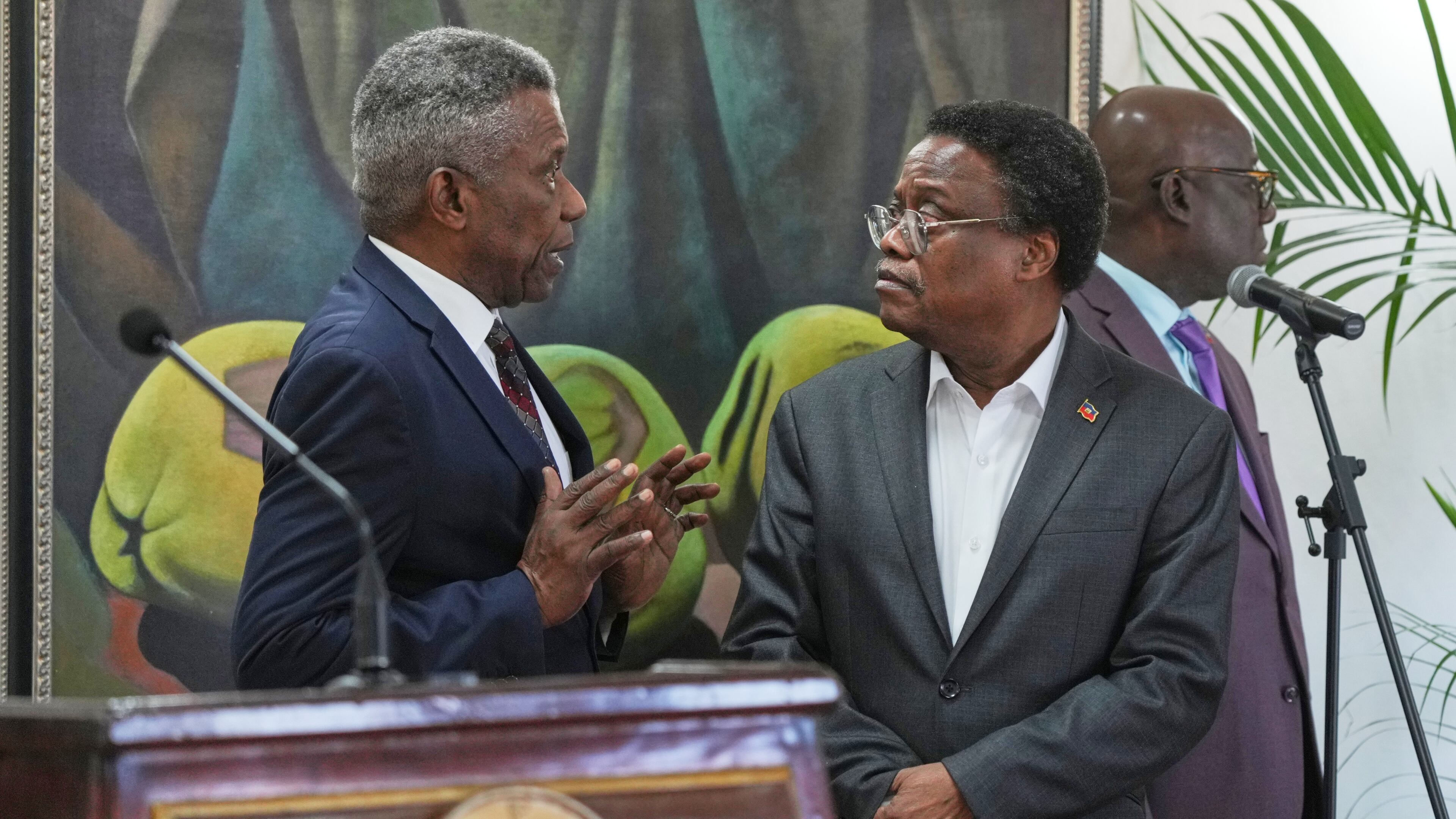 Chief of Protocol of the National Palace Marc Marie Yves Mazile speaks to Fritz Alphonse Jean, a member of Haiti’s transitional presidential council, before the start of a press conference in Port-au-Prince, Haiti, Tuesday, Nov. 25, 2025. (AP Photo/Odelyn Joseph)