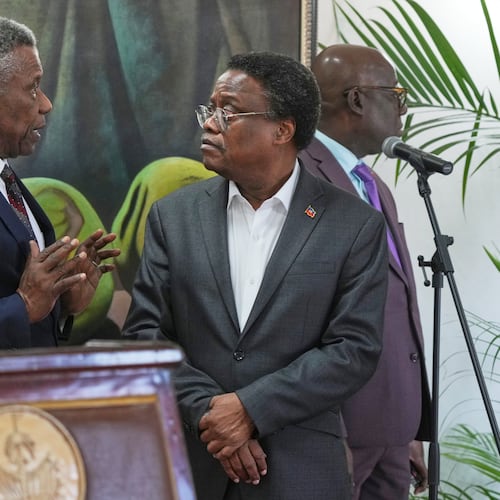 Chief of Protocol of the National Palace Marc Marie Yves Mazile speaks to Fritz Alphonse Jean, a member of Haiti’s transitional presidential council, before the start of a press conference in Port-au-Prince, Haiti, Tuesday, Nov. 25, 2025. (AP Photo/Odelyn Joseph)