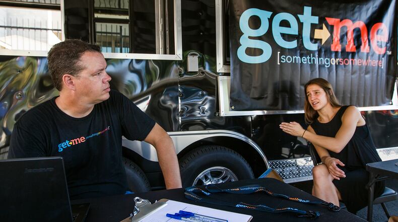 Get Me Rides & Deliveries employees Mark Amans, left, and Megan Monk sets up their sign up station outside of Aussie's restaurant on Barton Springs Rd, in Austin on Wednesday, Morning Sept. 23, 2015. Dallas-based Get Me is the latest app-based, on-demand ride and Delivery Company to launch in Austin, Texas. (RICARDO B. BRAZZIELL / AMERICAN-STATESMAN)