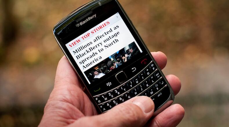 ORG XMIT: PCH101 A Blackberry user reads a story about a Blackberry outage that is affecting millions of users of the smartphone that has now spread to North America Wednesday, Oct. 12, 2011, in Montreal. Sporadic outages of BlackBerry messaging and email service spread to the U.S. and Canada on Wednesday, as problems stretched into the third day for Europe, Asia, Latin America and Africa. (AP Photo/The Canadian Press, Paul Chiasson) THE CANADIAN PRESS/Paul Chiasson