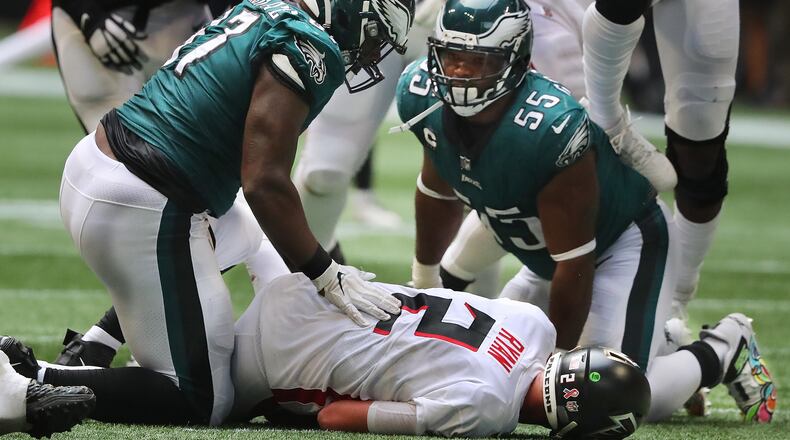 Falcons quarterback Matt Ryan lays on the turf taking a hard sack by Philadelphia Eagles defensive tackle Javon Hargrave (left) and defensive end Brandon Graham late in the fourth quarter Sunday, Sept. 12, 2021, at Mercedes-Benz Stadium in Atlanta. (Curtis Compton / Curtis.Compton@ajc.com)