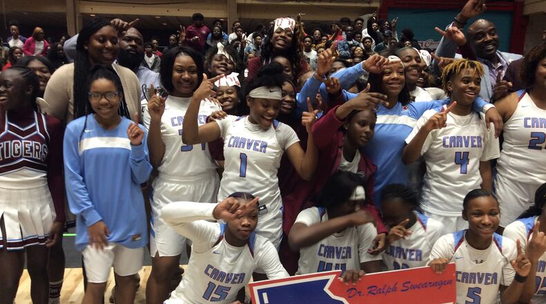 Carver-Columbus players and coaches celebrate the school's first state championship in girls basketball after beating defending champ Spalding 56-44 in the Class AAAA final Friday at the Macon Coliseum.