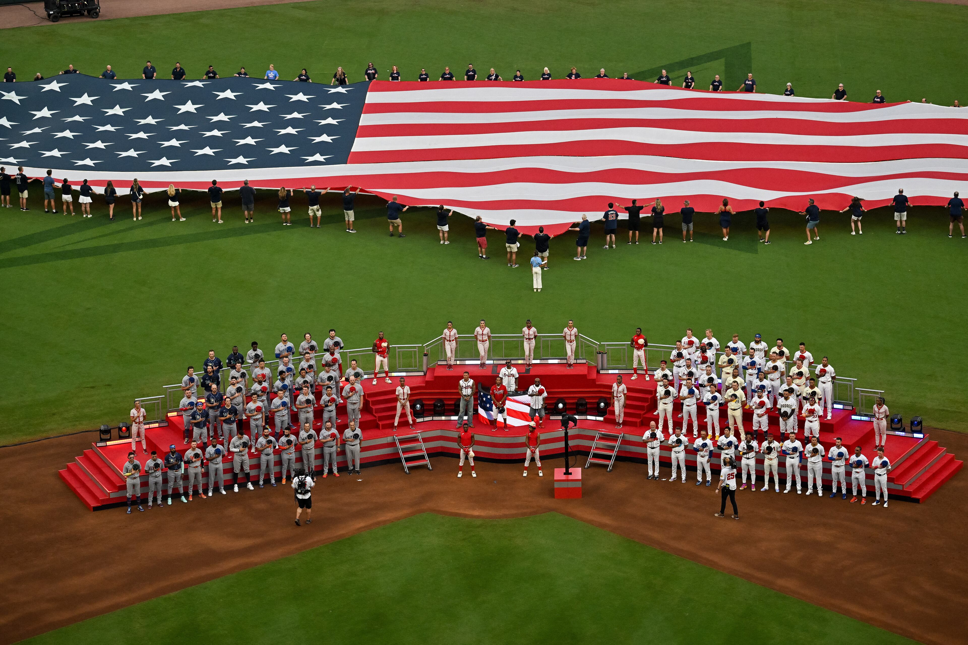 The U.S. flag is unfurled for the national anthem to help open the MLB All-Star Game at Truist Park in Atlanta on Tuesday, July 15, 2025. (Hyosub Shin/AJC)