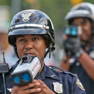 Officers T. Chambliss and D. Brown wait for speeders with their laser guns on Hope Street and Metropolitan Avenue to enter the school zone on Aug. 9, 2012. It's well -established that speeding doesn't really get you to your destination faster. (John Spink/AJC file)