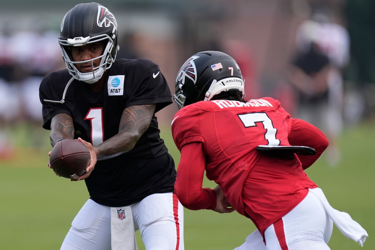 Atlanta Falcons quarterback Tua Tagovailoa hands the ball off to running back Bijan Robinson (7) during an NFL training camp, Friday, Aug. 7, 2026, in Flowery Branch, Ga. (Mike Stewart/AP)