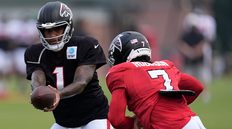 Atlanta Falcons quarterback Tua Tagovailoa hands the ball off to running back Bijan Robinson (7) during an NFL training camp, Friday, Aug. 7, 2026, in Flowery Branch, Ga. (Mike Stewart/AP)