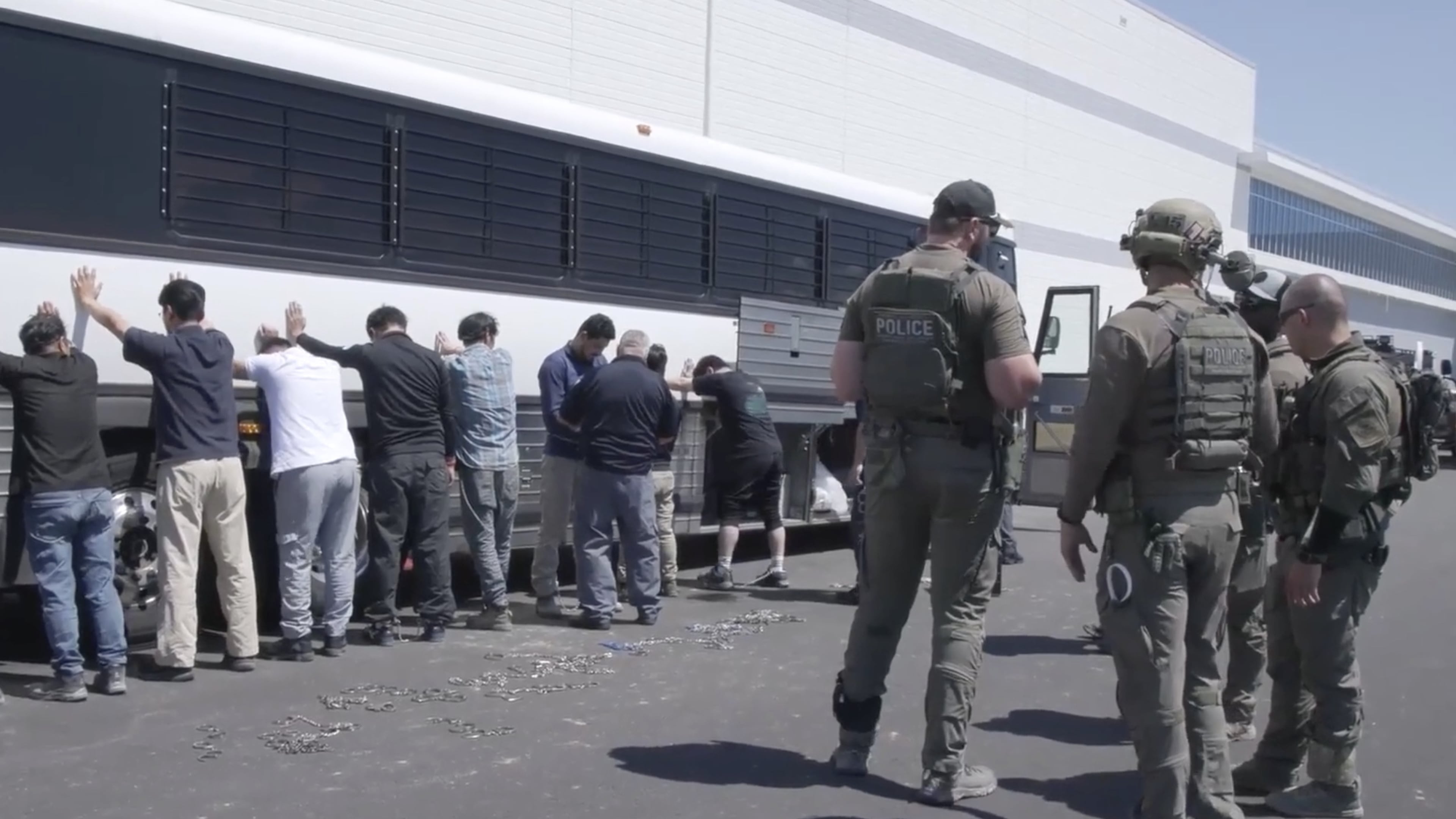 This image from video provided b U.S. ICE via DVIDS shows manufacturing plant employees waiting to have their legs shackled at the Ellabell Hyundai plant in September. (Corey Bullard/U.S. Immigration and Customs Enforcement via AP)