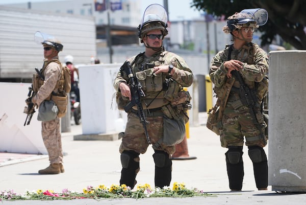 Members of the California National Guard and U.S. Marines guard a federal building on Tuesday, June 17, 2025, in Los Angeles. (AP Photo/Damian Dovarganes)