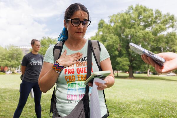 Board member Lorraine Irier reads from her phone to reporters during a rally outside the Decatur school district’s central office on Thursday, May 28, 2026. “This moment is bigger than one person in one event," she says. "It is about whether every child and family truly feels valued, protected, and welcome in this community and district." (Estela Muñoz/AJC)