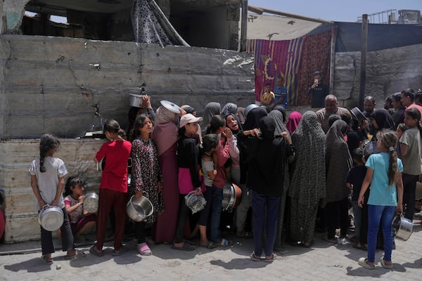 Palestinians line up for donated food at a community kitchen in Jabalia, in the northern Gaza Strip, on Monday, May 19, 2025. (AP Photo/Jehad Alshrafi)