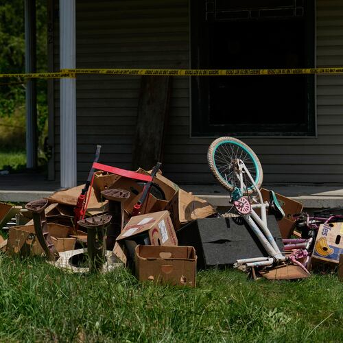 Police tape and debris are seen at a home where authorities say they removed 16 children and arrested four adults in Hamden, Ohio, Wednesday, July 1, 2026. (AP Photo/Carolyn Kaster)