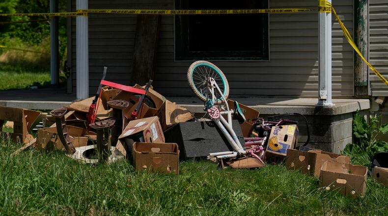 Police tape and debris are seen at a home where authorities say they removed 16 children and arrested four adults in Hamden, Ohio, Wednesday, July 1, 2026. (AP Photo/Carolyn Kaster)