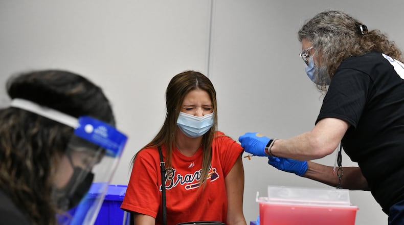 Braves fan Emily McCormick of Johns Creek reacts as she receives a COVID-19 vaccine at Truist Park on Friday, May 7, 2021. (Hyosub Shin / Hyosub.Shin@ajc.com)