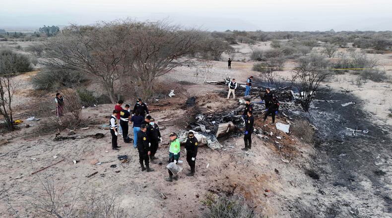 Police inspect the wreckage of a plane that crashed during a sightseeing flight carrying tourists over the Nazca Lines in Peru, Saturday, Aug. 1, 2026. (AP Photo/Genry Bautista)