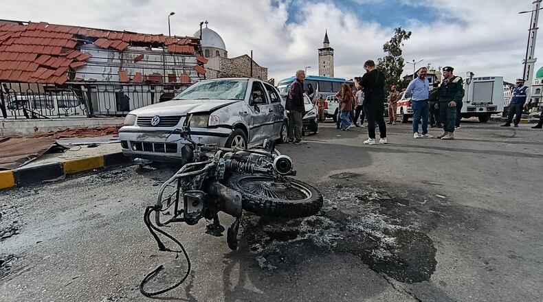 Syrian security personnel inspect the site of an explosion outside a Defense Ministry building in Damascus, Syria, Tuesday, May 19, 2026. (AP Photo/Abdulrahman Shaheen)