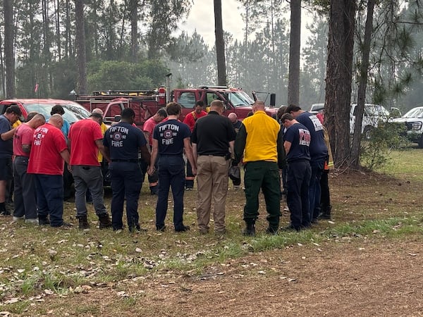 U.S. Sen. Raphael Warnock prays with first responders as he visits Brantley County to survey damage from wildfires on Monday. (Courtesy of the office of U.S. Sen. Raphael Warnock)