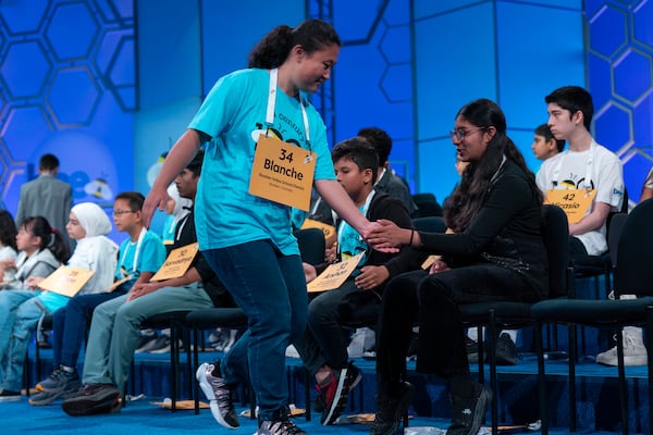 Blanche Yang Li, 14, of Boulder, Colo., high fives her friends after correctly spelling her word as she competes during the first preliminary round of the Scripps National Spelling Bee at the Gaylord National Resort & Convention Center, Tuesday, May 27, 2025, in Oxon Hill, Md. (AP Photo/Jose Luis Magana)g