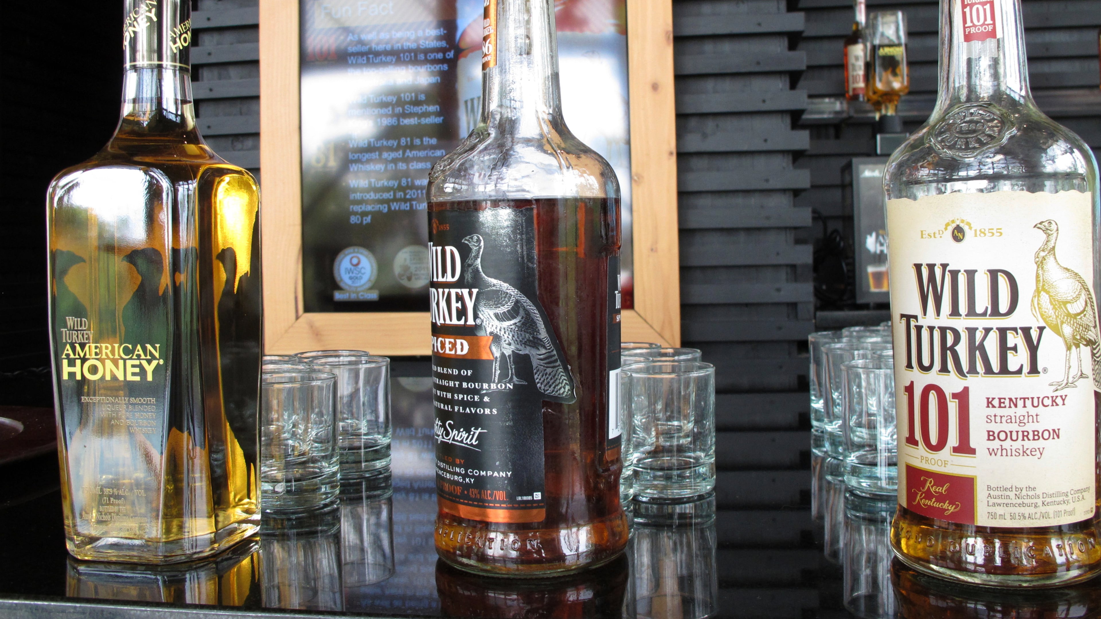 FILE- In this Aug. 22, 2014, file photo, Wild Turkey sampling bottles sit on the bar at the distillery's visitors' center near Lawrenceburg, Ky. (AP Photo/Bruce Schreiner, File)