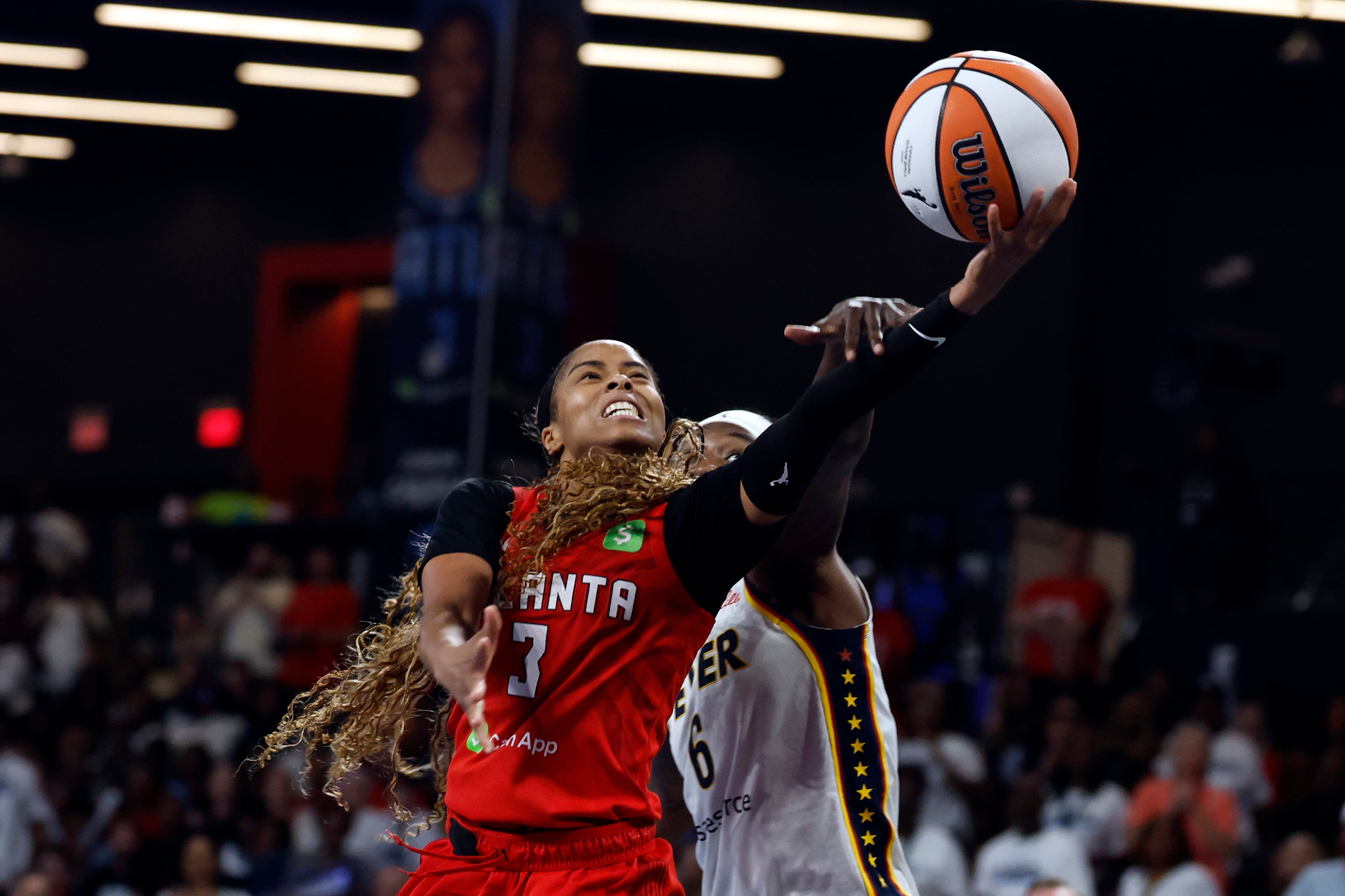 Atlanta Dream guard Jordin Canada (3) is fouled by Indiana Fever forward Natasha Howard (6) as she looks to shoot during the second half of Game 3 in the first round of the WNBA basketball playoffs, Thursday, Sept. 18, 2025, in Atlanta. (AP Photo/Butch Dill)